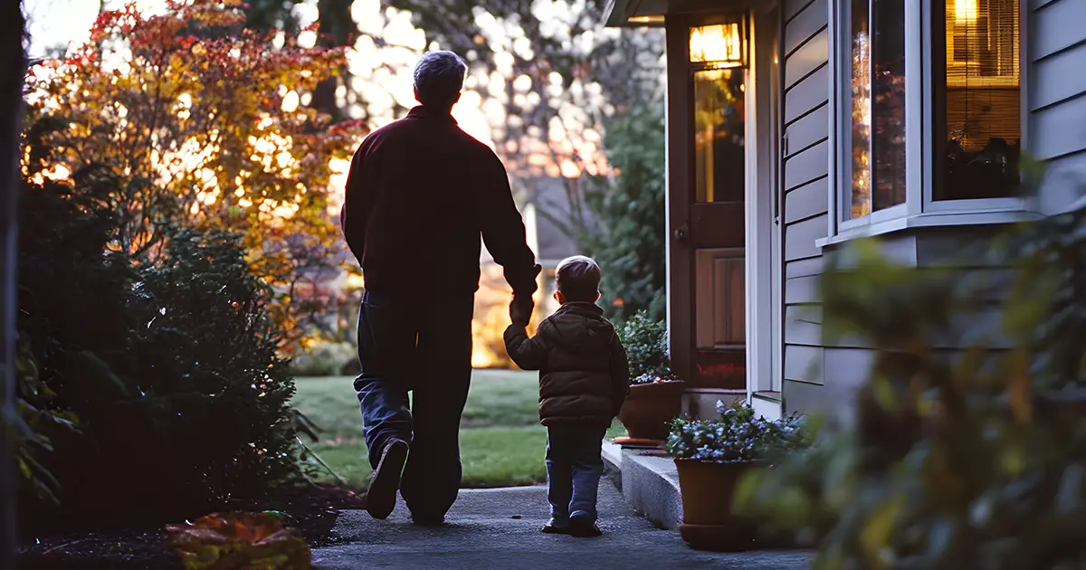 man and child walking in front of home